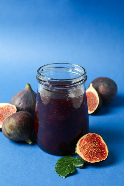 istock Jars with fig jam and ingredients on blue background 1495058895