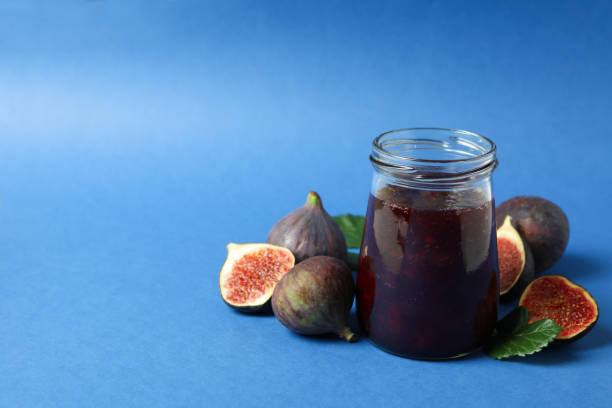 istock Jars with fig jam and ingredients on blue background 1495059459