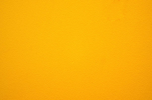 Yellow wall texture background.The stone wall surface painted with enamel paint.Selective focus.