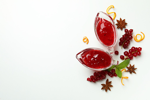Cranberry sauce and ingredients on white background