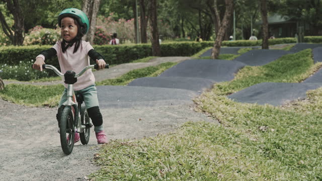 Little girl with helmets practicing a bike