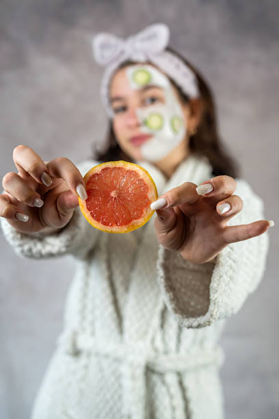istock young woman with a face clay mask and grapefruit cucumbers 1495075955