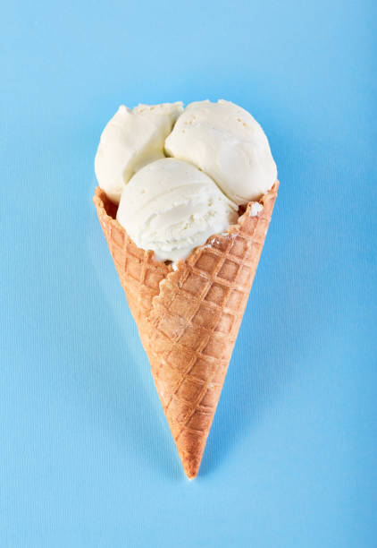istock ice cream balls in a Waffle Cone on a Blue Background. Vanilla ice cream in a waffle cone. 1495077425