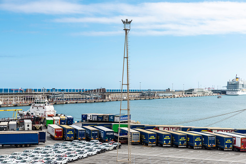 Barcelona, Spain - April 17, 2023: Loading dock with container trailers and cars at the port of Barcelona, Catalonia, Spain