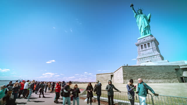 Time lapse of Crowd tourists walking and sightseeing at Statue of Liberty enlightening the world on Liberty Island in New York City, United States