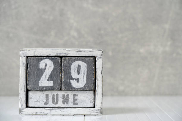 istock Calendar for June 29, made wooden cubes, against light concrete wall.With an empty space for your text. 1495083644