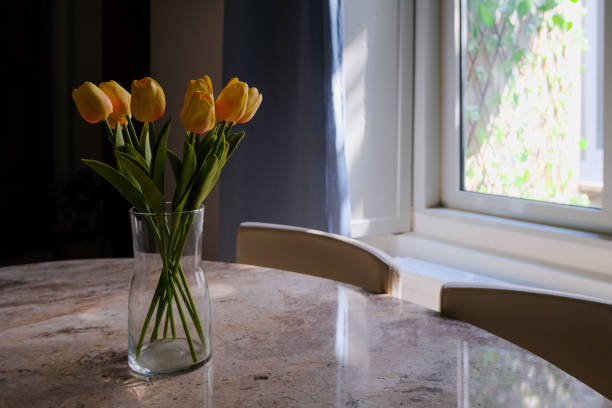 istock yellow tulips in vase on the table. flowers in home interior 1495084251