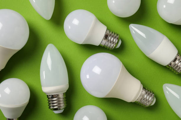 istock Energy saving bulbs on green background, top view 1495084362