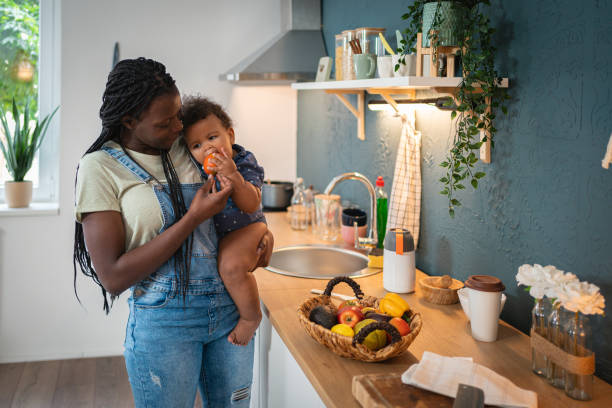 istock Mother Black ethnicity holding her son in the kitchen 1495085099