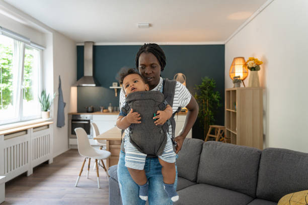istock Mother Black ethnicity adjusting baby carrier, with her son in it 1495085314