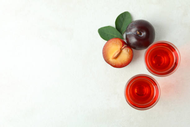 istock Plum brandy shots and ingredients on white textured table 1495087889