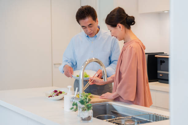 台所で一緒に料理を楽しむ老夫婦 - senior male ストックフォトと画像