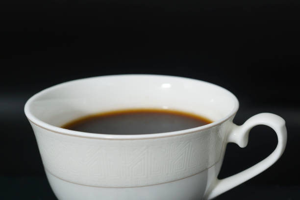 Coffee in brown cup on white background, top view