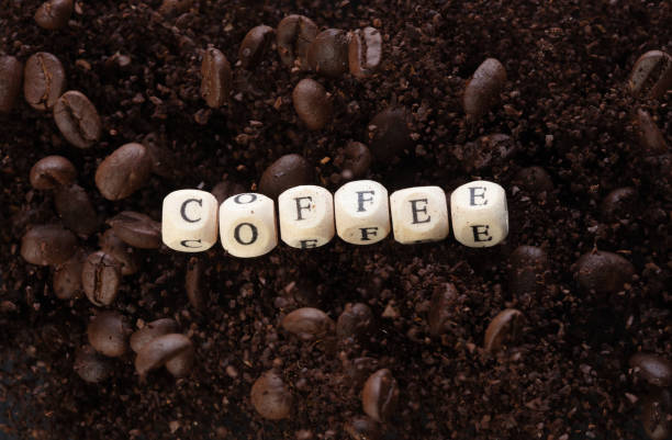 Coffee alphabet letter word bead fly with powder seed. Coffee roasted concept to refresh morning work. Coffee mix bean dust powder, alphabet letter word concept. Black background isolated