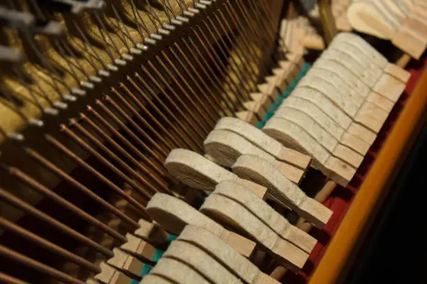 A close-up of the internal parts of a piano or grand piano. Selective focus. Details of the musical instrument from the inside. Hammers and strings inside a piano. Part of the internal mechanism