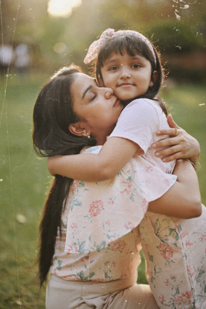 istock Mother embracing her daughter in a park 1495095094