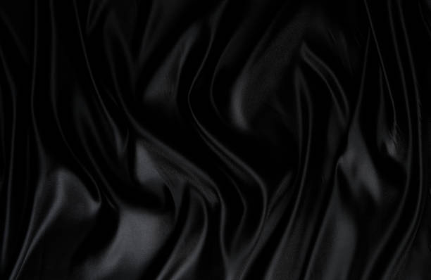 istock Silk fabric, abstract wavy black satin fabric background. 1495095797