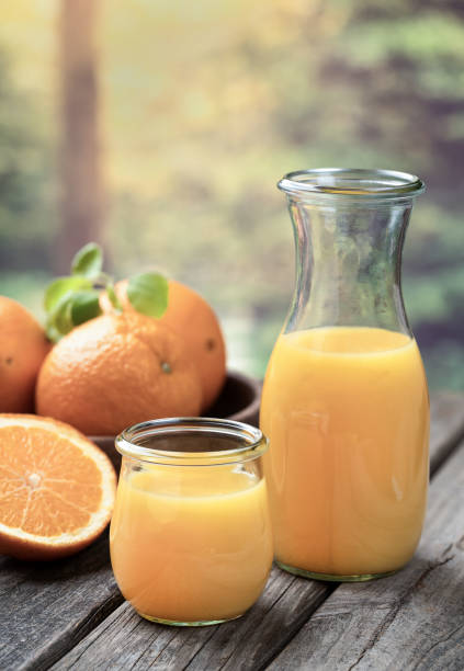 istock Orange juice in glass and carafe with fresh oranges 1495096852