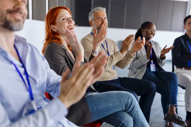 istock Smiling people applauding at a business training 1495097331