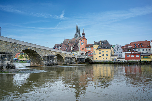 Old medieval stone bridge and historic old town in Regensburg, Germany.