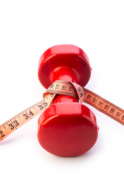 istock Diet and exercise, red dumbbell and measure tape 1495100192