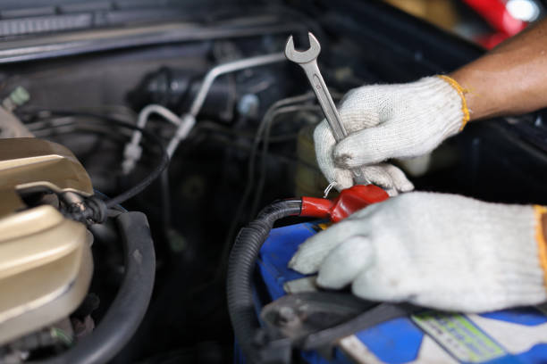 open car hood with pliers and working gloves left on the engine, outdoor closeup