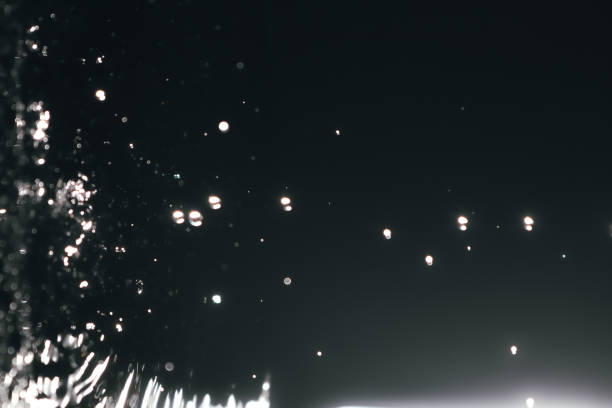 istock Blur abstract background with bokeh defocused lights and shadow. Dark water drops background. Trendy abstract nature background. 1495104529