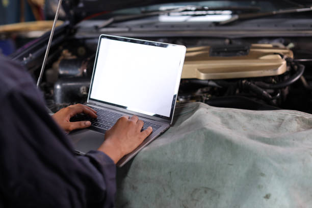 istock Woman technician car mechanic hands in uniform checking maintenance a car service with computer at repair garage station. Car repair service concept 1495105015