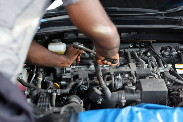 istock Man technician car mechanic hamds in half uniform checking maintenance a car service at repair garage station. Worker holding wrench and fixing breakdown vehicle. Concept of car center repair service. 1495106264