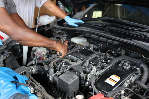 istock Man technician car mechanic hamds in half uniform checking maintenance a car service at repair garage station. Worker holding wrench and fixing breakdown vehicle. Concept of car center repair service. 1495106279