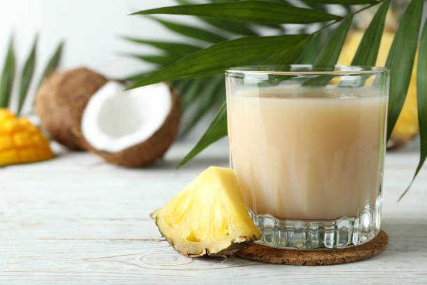 istock Pina colada cocktail and ingredients on white wooden table 1495108332