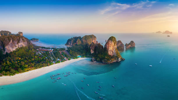 夕暮れ時のライリービーチのパノラマ、クラビ、タイ。 - thailand beach longtail boat cliff ストックフォトと画像