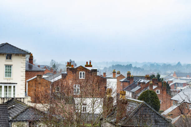 In this picturesque photo, a captivating winter scenery unfolds in a quaint English town. The scene is adorned with a gentle snowfall, transforming the landscape into a magical winter wonderland. The old English buildings that line the streets add a touch of historic charm and timeless elegance to the setting.