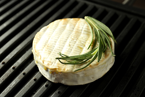 Grilled camembert on electric grill, close up.
