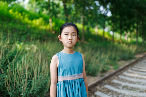 Little girl standing by the railway