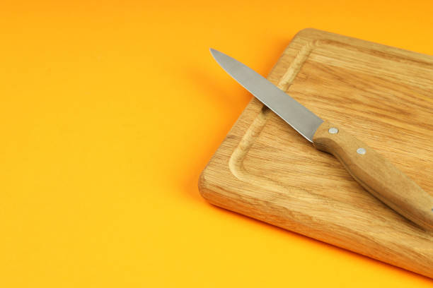 istock Cutting board with knife on orange background 1495119156