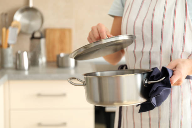 istock Woman in apron holds metal pot, space for text 1495121415