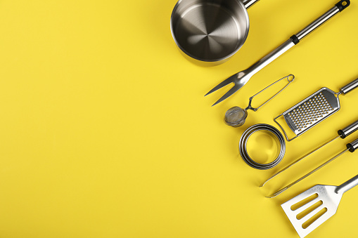 Kitchen utensil on yellow background, space for text.