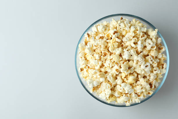 istock Glass bowl with popcorn on light gray background 1495123047