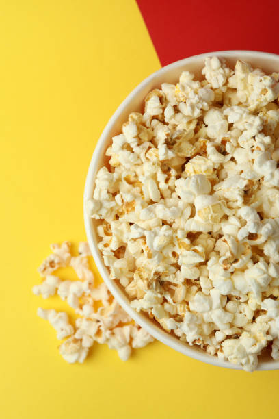 istock Striped paper cup with popcorn on two tone background 1495124564