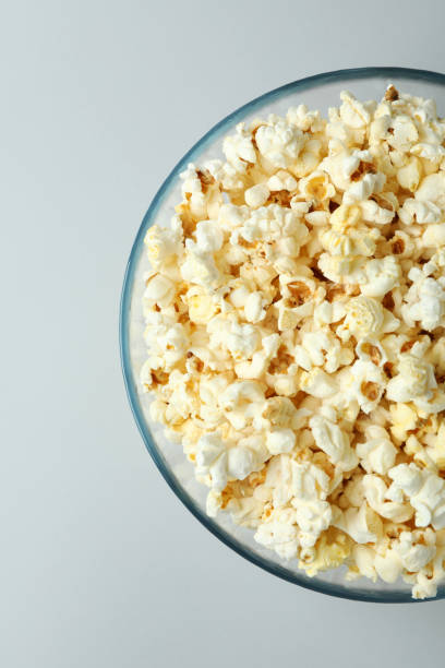 istock Glass bowl with popcorn on light gray background 1495124611