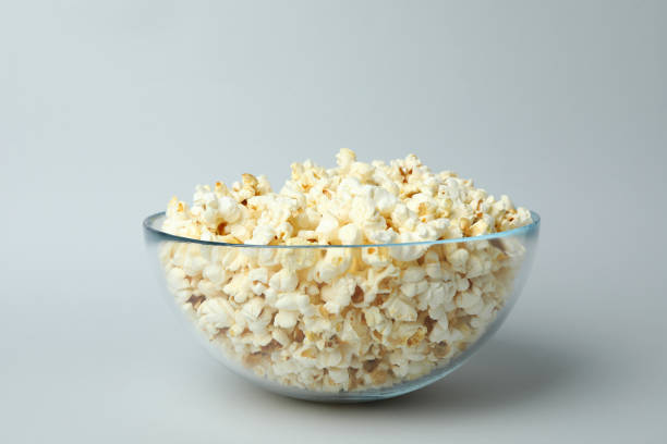istock Glass bowl with popcorn on light gray background 1495124691