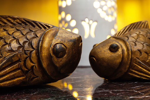 Two decorative fish carved from wood on the table.