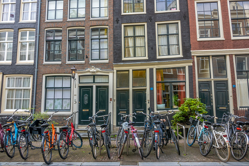 Netherlands. Summer day in Amsterdam. Several bicycles are parked in front of the dancing facades of typical Dutch townhouses