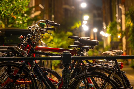 Netherlands. Summer night in Amsterdam. Several parked bikes and street lights in an alley