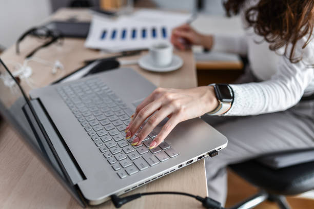 istock Female Accountant Making Calculations And Writing Down Data While Typing On Laptop 1495130624