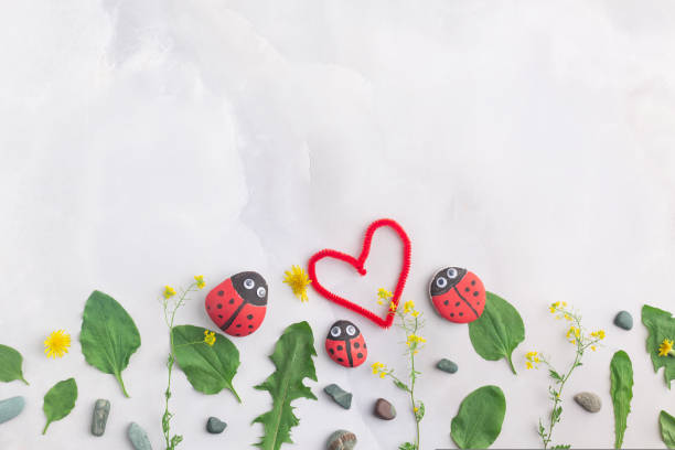 Drawing a ladybug on a stone with acrylic paints. Home hobbies are authentic. Artwork on stones. High quality photo