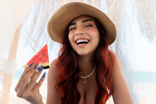 Young woman eating watermelon.