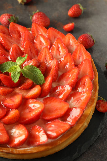 istock Tray with strawberry tart on dark textured table 1495138037