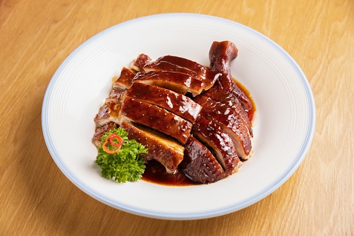 A closeup of a plate with gilled duck slices with a sauce